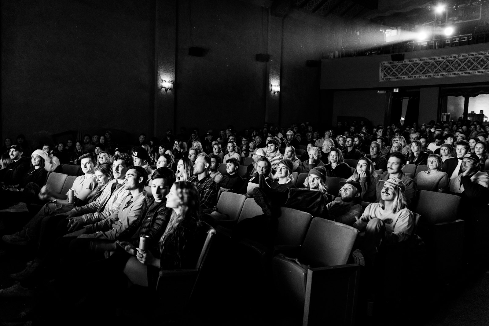 Foule en noir et blanc, visages tournés dans la même direction.