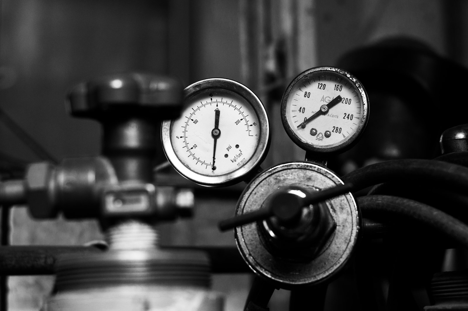 Deux manomètres en gros plan sur un équipement, en noir et blanc.
