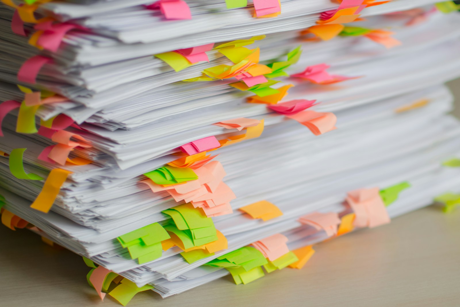Pile de documents annotés de marque-pages colorés, évoquant un corpus de textes de référence.