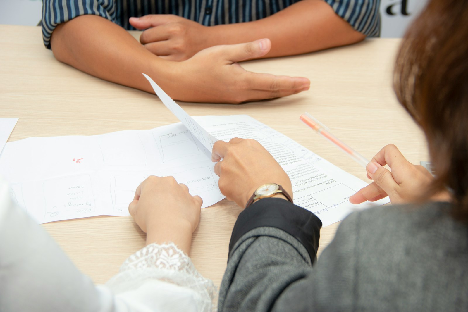 Deux personnes relisent un document imprimé sur une table de réunion.