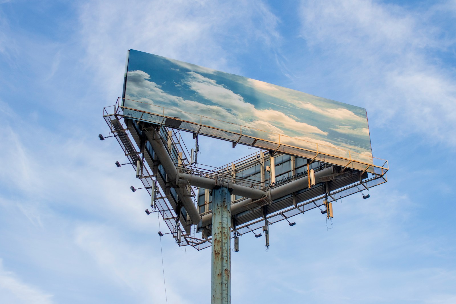 Panneau publicitaire géant dont l'affiche ne montre qu'un ciel bleu et des nuages.