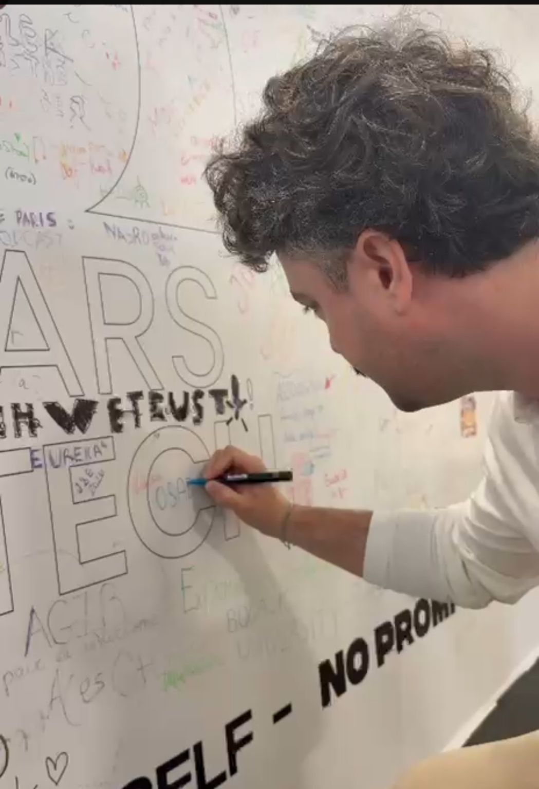 Antoine Crespin inscrit « OSAD » sur le mur des signatures « In Tech We Trust » à VivaTech.